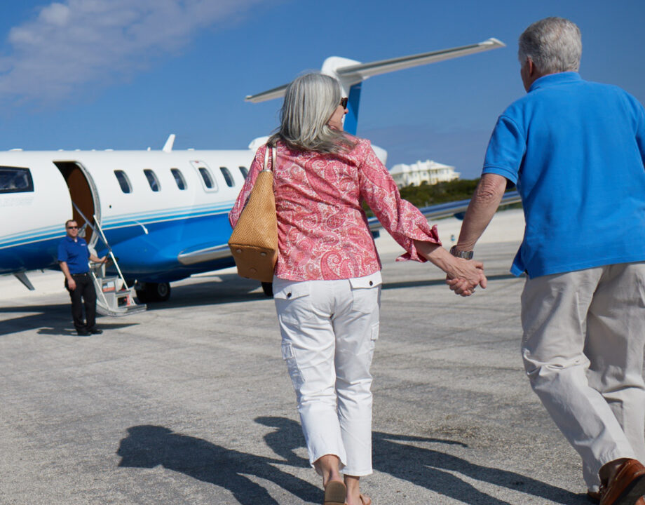 Couple walking towards Pilatus PC-24 jet. lifestyle